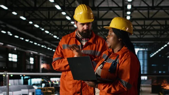 Engineering team transmitting instructions via wireless radio device, reviewing production line operations in machinery hall. People using walkie-talkie for manufacturing coordination, factory.