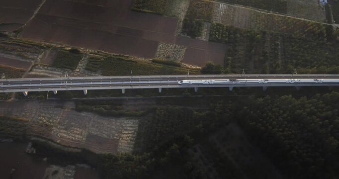 High-speed railway train traveling on the Beijing&ndash;Shanghai High-Speed Railway (Jinghu HSR) in China. Modern bullet train running on elevated tracks through the countryside, showcasing advanced transpo