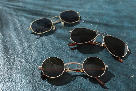 Different stylish sunglasses on dark background
