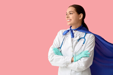 Beautiful female doctor in superhero costume on pink background © Pixel-Shot