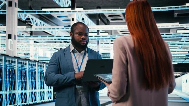 Data center team of technicians uses AI deep learning on devices to optimize performance. Software developers brainstorm how to integrate neural network automation in data center operations, camera A