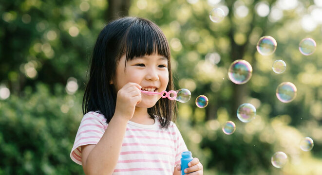 シャボン玉で遊ぶ笑顔の女の子：公園での外遊び、子供の日常風景　Generative AI