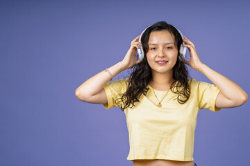 Naklejka premium Young woman enjoying music wearing white headphones
