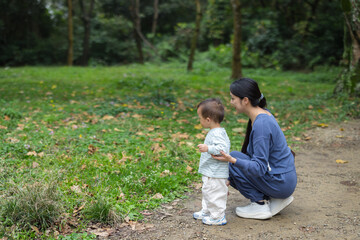 Fototapeta premium Mother and baby relaxing together in green nature