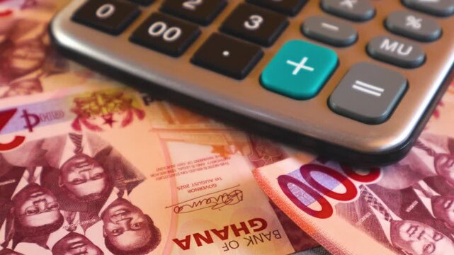 Close-up of Ghana Cedi banknotes (GHS) and a calculator. The scene represents financial calculations, budgeting, and the Ghanaian economy through a slow, detailed pan across the currency.