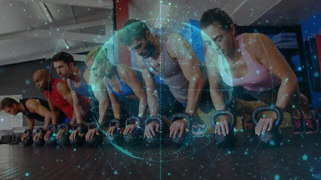 On cue group pressing up kettlebell handles on wood floor, pulsing globe over torsos for fitness