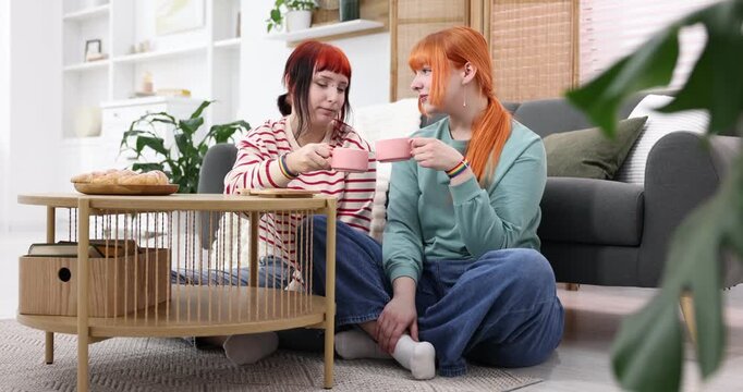 Lovely lesbian having coffee together at home. LGBT concept