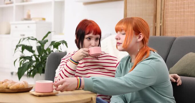 Lovely lesbian having coffee together at home. LGBT concept