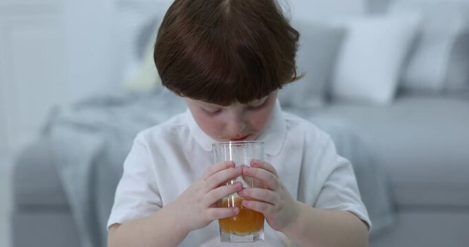 Little boy stained shirt while drinking juice at home