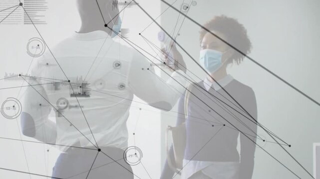 On arrival staff doing temp scan then dispensing sanitizer for health screening with data overlays