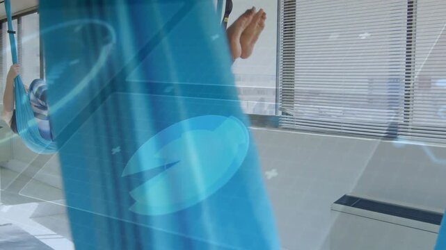 Lead woman pulling hammock up, tucking and inverting for yoga stretch, blue overlay showing motion