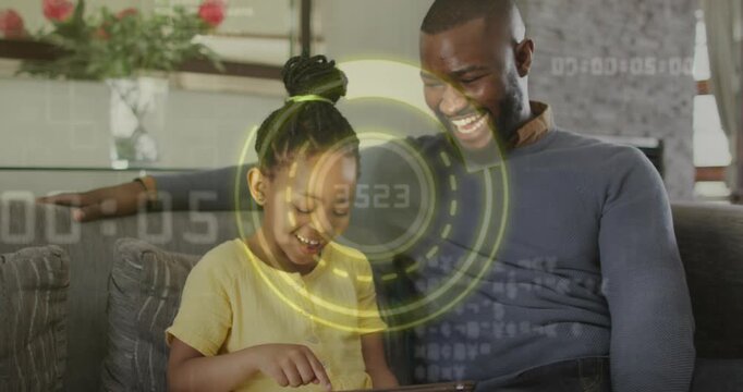 Dad and daughter sitting couch daughter tapping tablet causing HUD rotating technology dad pointing