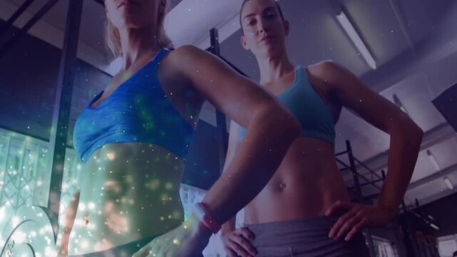 Two female fitness models promoting fitness, camera lifting revealing sparkle overlay on left torso