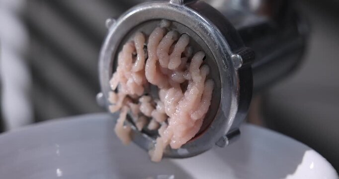 Man making minced meat with grinder indoors, selective focus