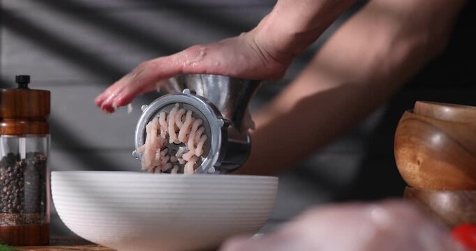 Man making minced meat with grinder at table, closeup. Camera moving in