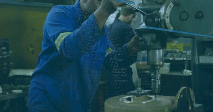 Machinist in machine shop aligning clamp, rotating feed lever, lowering spindle to drill part