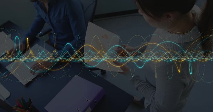 Woman showing orange chart, man reaching and using mouse, reviewing business charts under waveform