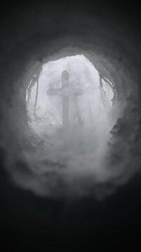 Cave filled with fog slowly revealing a crucifix in the opening of the empty tomb. Symbolic of the resurrection of Jesus Christ. Good Friday, He is Risen concept. Symbolizing faith or god in heaven.