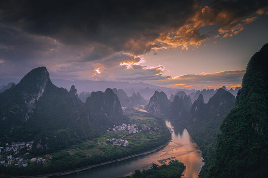 First rays of light through the clouds in Xianggong hill of Guilin, Li River and Karst mountains