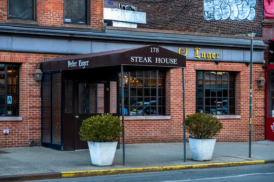 Brooklyn, NY - US - Mar 14, 2026 Classic facade of Peter Luger Steak House in Williamsburg, Brooklyn, with iconic awning, brick exterior, and quiet street scene.