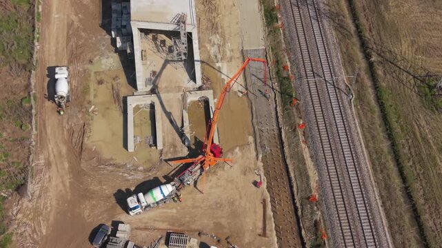 Construction Site in Action: An aerial view captures the dynamic process of concrete pouring at a construction site, showcasing industrial machinery and ongoing development.