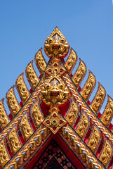 Fototapeta premium Traditional Thai Architectural Decorative Detail with Gilded Carvings and Glass Mosaic.
