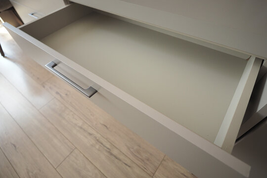 Open drawer in modern furniture setup displays empty space