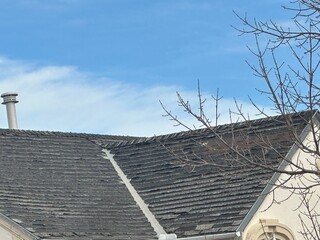 Worn and deteriorating roof shingles showing need for residential repair and inspection © Berta