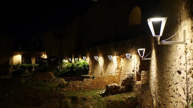 The illuminated walls of the Sant Pere bastion on a dark and windy winter night. Palma de Mallorca, Spain.