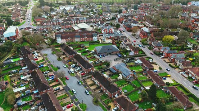 aerial drone landscape shot over Romsey, Hampshire, England Town village in spring sunset surrounded by nature trees and fields with golden warm light above. Calm quiet roads and paths below