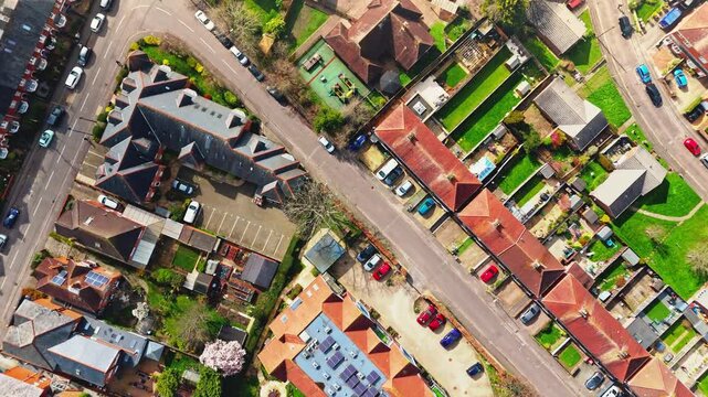 aerial drone landscape shot over Romsey, Hampshire, England Town village in spring sunset surrounded by nature trees and fields with golden warm light above. Calm quiet roads and paths below