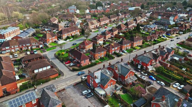 aerial drone landscape shot over Romsey, Hampshire, England Town village in spring sunset surrounded by nature trees and fields with golden warm light above. Calm quiet roads and paths below