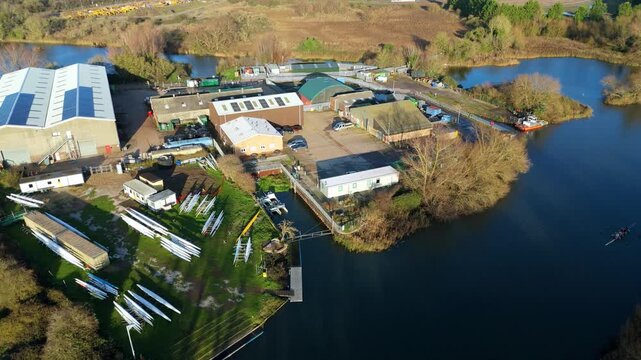 Aerial view of a modern rowing club house on the banks of the River Great Ouse in Ely Cambridgeshire during a serene golden hour sunset
