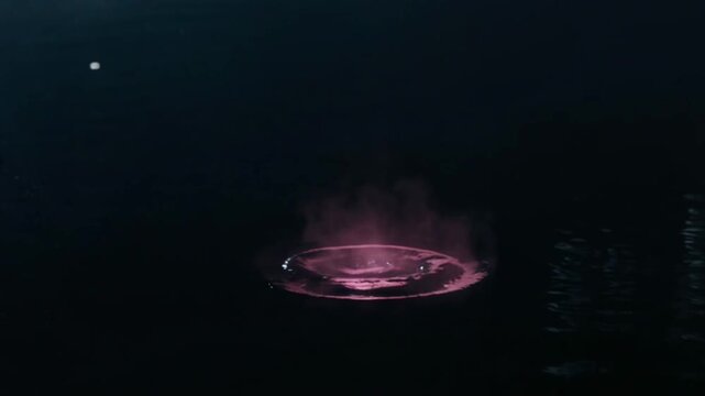 水面に落ちた夜桜が霧になるティルトダウン映像