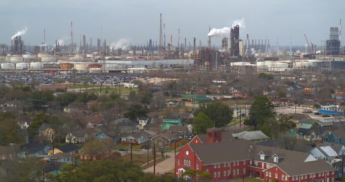 Establishing reveal shot of homes near heavy industry and chemical plants in the Baytown, Texas area