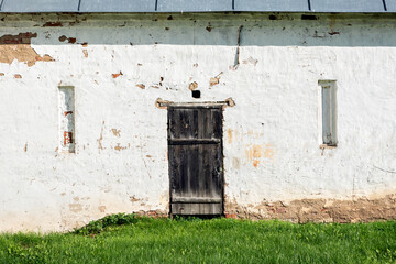 Old wooden door in a brick wall with white plaster. From the Doors of the World of the world series. © dotsent