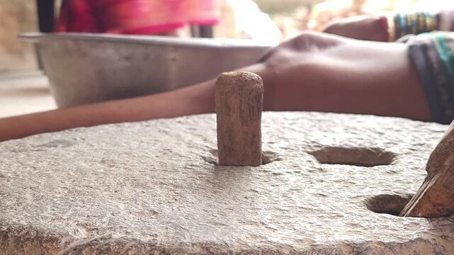 Close-Up of Woman Hand Operating Traditional Stone Grinder Chakki in India, Manual Grain Grinding Process, Rural Kitchen Tool, Authentic Village Lifestyle, Organic Food Preparation 4K Footage