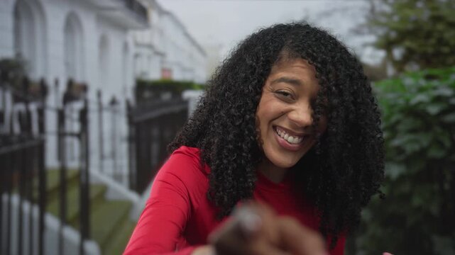 African american woman pointing finger to camera at building entrance; shared authentic joy and laughter.