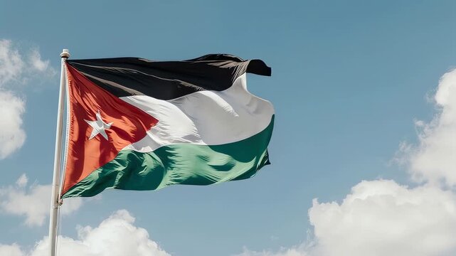The flag of Jordan waves proudly against a vibrant blue sky with scattered white clouds, creating a patriotic and nationalistic atmosphere