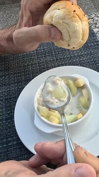 Delicious Dessert Experience: A Close-Up of Hands Enjoying a Sweet Treat with Bread, Fruit, and Creamy Delight in a Chic Cafe Setting