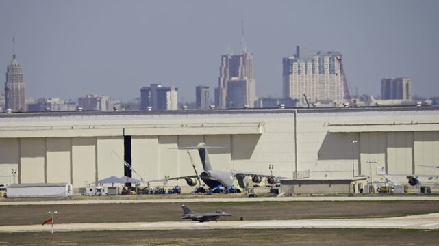 F-16 Taxiing on Runway Air Base with City Skyline in Background. San Antonio TX.