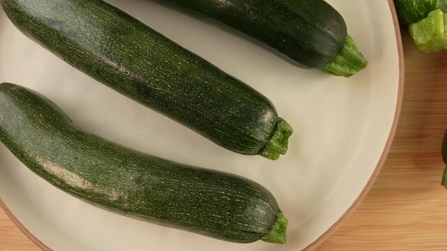 Fresh green zucchini on wooden background top view.