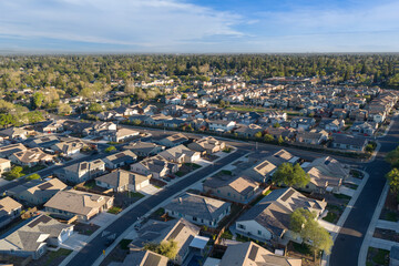 Fototapeta premium defauWide aerial view of suburban neighborhood with single family homes, residential streets, and expansive tree lined community, elevated drone perspective of modern housing development