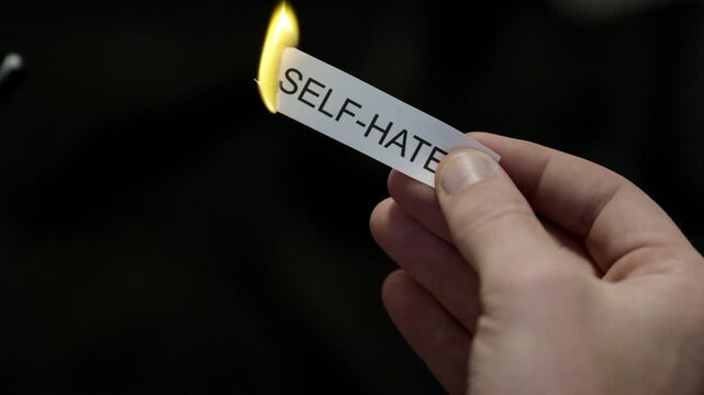Burning Away Self Hate - Hand Setting Fire to Paper note Marked &ldquo;SELF - HATE&rdquo;, Powerful Release of Criticism, Guilt and Shame, Dark Cinematic Close-Up. Mental health, therapy