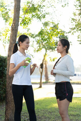 Obraz premium Two sporty Asian woman talking together in park