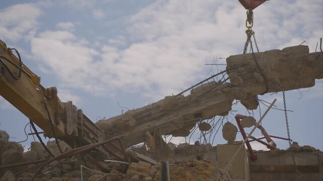 Destruction of the building. Operation of an excavator with a hydraulic hammer and a crane
