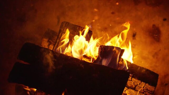 Bright Flames Ignite Dark Wood. Vivid Orange Flames Dance Lively Over Burning Timber Sparks. Intense Crackling Sounds Emerge As Fiery Logs Radiate Vivid Orange Flames And Billow Smoke
