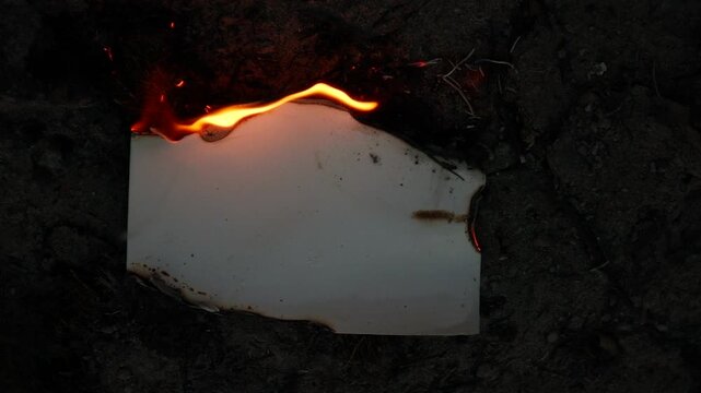 Burning and glowing photo or paper with fire flame and smoke on dark background