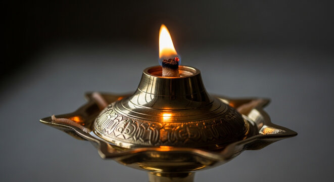 Traditional oil lamp with a lit wick and intricate design