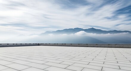 Fototapeta premium Empty concrete rooftop terrace overlooking a misty mountain range under a cloudy sky